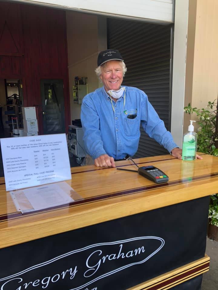 Greg smiling, behind the bar, ready to welcome customers